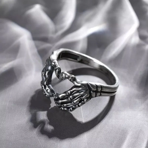 Detailed view of vintage gothic skeleton hands forming a heart shape in silver finish