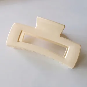 Close-up of a cream matte rectangular hollow hair claw clip with minimalist Korean style