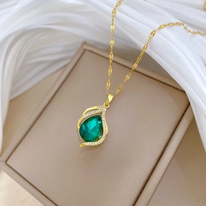 Luxurious gold necklace featuring a green teardrop gemstone and sparkling diamonds