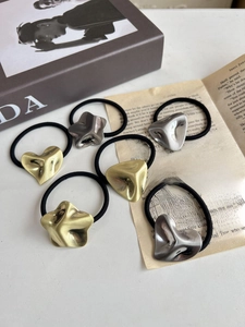 Detailed set of six gold and silver geometric elastic hair ties on vintage paper