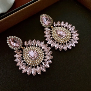 Vue macro de boucles d'oreilles vintage en cristal rose avec design halo tournesol doré
