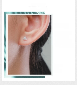 Detail of s925 silver stud earring with three-stone floral micro-inlay on female model