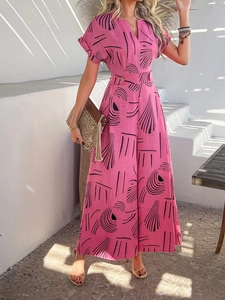 Detail of pink printed jumpsuit with V-neck and button waist in Mediterranean setting