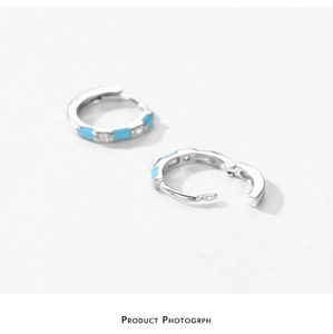 Macro shot of S925 silver hoop earrings with sky blue enamel and clear zircon stones