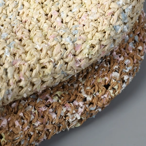 Macro view of hand-crocheted summer straw sun hat texture with colorful thread accents