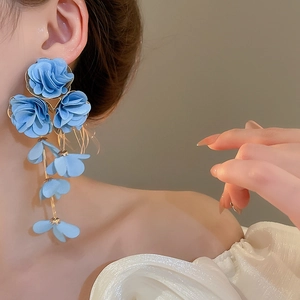 Detail of blue chiffon fabric flower drop earrings with golden chain and delicate petals