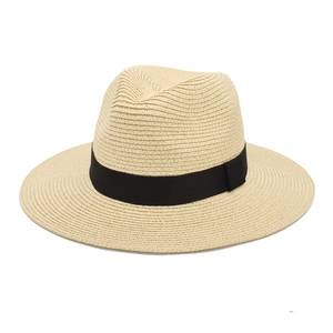 Close-up of beige straw Panama hat with woven texture and a wide black grosgrain ribbon