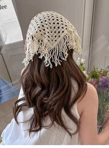 Detail of crochet knit hollow triangular hair scarf featuring elegant tassel fringe edges
