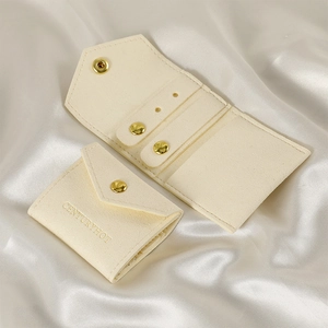 Detail of cream microfiber jewelry roll with gold snap button and ear stud holder