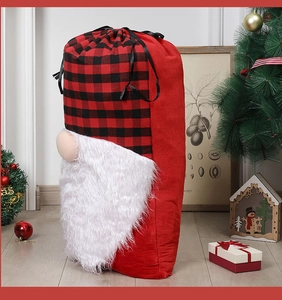 Detail of red buffalo plaid gnome Christmas gift bag with white faux fur beard and drawstring