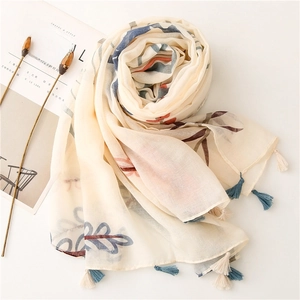 Close-up of beige linen scarf with small flower patterns and tassels on Cereal magazine