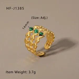 Detailed view of an 18k gold plated vintage ring with three green stones and 14mm width