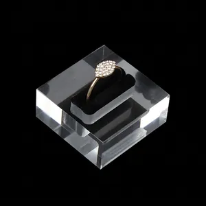 Golden marquise-cut crystal ring displayed on a clear acrylic block with black velvet