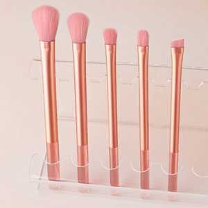 Detailed close-up of 5 pink makeup brushes with crystal glitter handles on acrylic stand