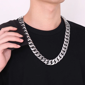Close-up of thick silver stainless steel Cuban chain necklace worn by male model