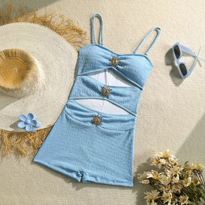 Detail of light blue ribbed swimsuit with diamond cut-outs and golden sun buckles