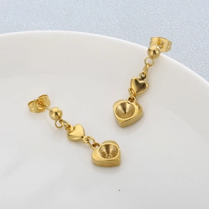 Orecchini a cuore dorati in acciaio inossidabile 18K su superficie in ceramica bianca