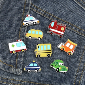 Detailed macro view of colorful cartoon vehicle enamel pins on blue denim fabric