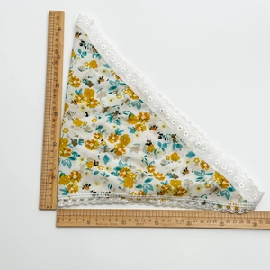 Detail of floral lace headscarf showing 30cm measurements on wooden rulers