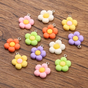 Colorful 21x24mm resin flower pendants for DIY necklaces and bags shown on wood background