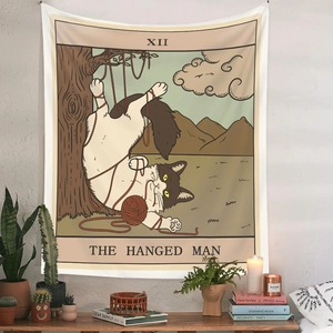 Detail of tarot cat wall tapestry hanging above wooden desk with succulent plants