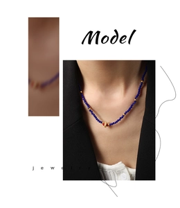 Detail of beaded necklace featuring blue faceted stones and a gold cutout center bead