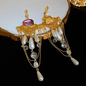 Vue détaillée des boucles d'oreilles vintage dorées avec cristaux violets et perles
