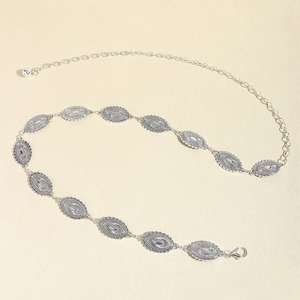 Detail of vintage silver metal waist chain featuring sunburst engraved oval link plates