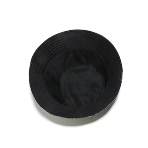 Detail of black reversible bucket hat showing inner lining and colorful floral edge stitching