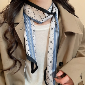 Detail of silk scarf necklace with blue and white geometric print worn on model