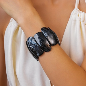 Close-up of black and white marbled acrylic bracelet on model wrist with polished resin finish