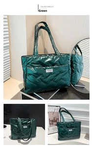 Close-up of green quilted tote bag featuring a square fashion label and glossy texture