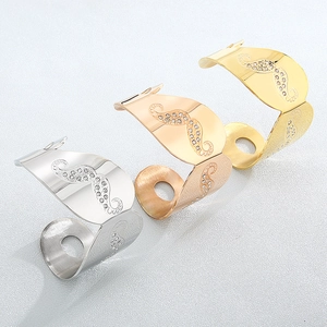 Three open metal rings in gold, rose gold and silver with wavy texture and rhinestones