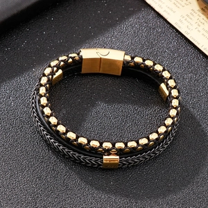 Detail of multi-layer leather braid bracelet with gold beads and magnetic clasp