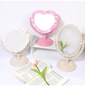 Detailed view of vintage tabletop mirrors in heart and oval shapes with floral carvings