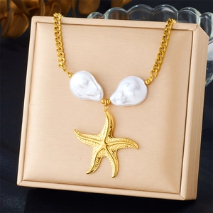 Detail of gold starfish necklace featuring two large white baroque pearls on jewelry box