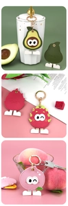 Detailed view of fruit-shaped PU leather keychains in avocado and peach designs