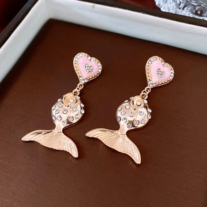 Detailed close-up of fish-shaped pendant earrings with pink heart studs and rhinestones