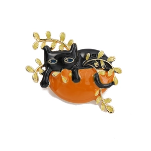 Detailed close-up of an enamel cat brooch with black kitten on orange base and vines