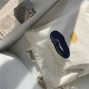 Detail of canvas tote bag with blue abstract patterns and refreshment lettering
