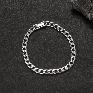 Polished silver Cuban link bracelet with square clasp on black stone background