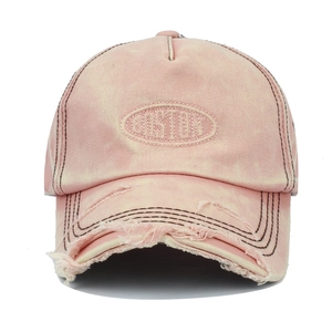Close-up of pink washed cotton baseball cap with Boston embroidery and distressed brim