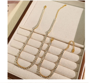 Détail de l'ensemble collier et bracelet doré élégant serti de strass brillants sur un rang