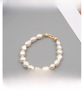 Detailed macro view of baroque freshwater pearls and gold-tone lobster clasp closure