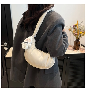 Détail du sac hobo matelassé beige avec un charmant lapin en peluche sur l'épaule