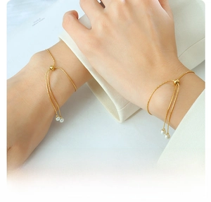 Detail of adjustable 18k gold plated titanium steel pearl bracelets worn on wrist