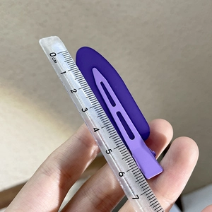 Detail view of a 6cm purple matte duckbill hair clip with a ruler for size measurement