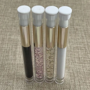 Detailed overhead shot of four stylish mini round lip brushes on beige textured fabric