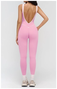 Detailed back view of pink yoga jumpsuit featuring U-shaped back and white contrast piping