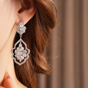 Gros plan de boucles d'oreilles pampilles en argent avec détails de feuilles en zircone